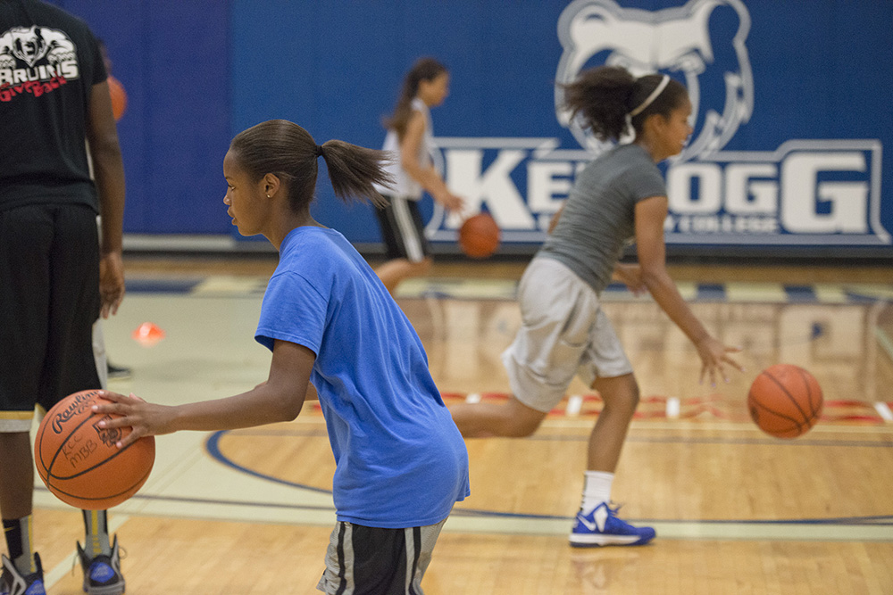 Youth basketball campers dribble during drills at a youth basketball camp in KCC's Miller Gym.