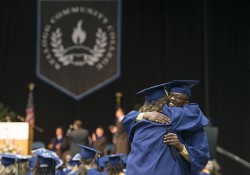Graduates hug during KCC's 2014 commencement ceremony.