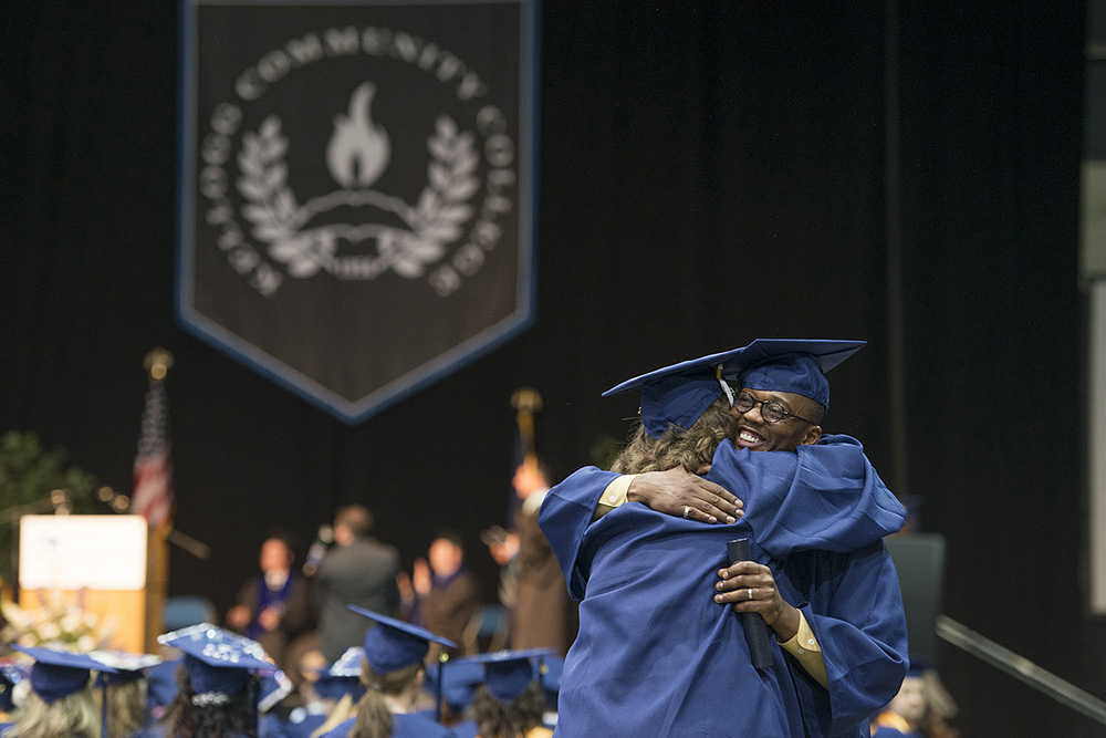 Graduates hug during KCC's 2014 commencement ceremony.