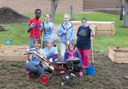 KCC students and employees pose while working in KCC's community garden.