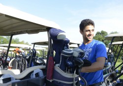 A KCC baseball player volunteers securing golf bags during the 2014 Bruin Scholarship Open.