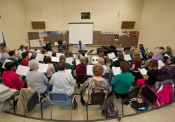 Members of KCC choirs rehearse in a music room.