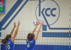 KCC women's volleyball players block the ball during a home game at the Miller Gym.