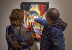 Exhibit goers look at a painting at the KCC Faculty Biennial Art Exhibition in February at the Art Center of Battle Creek.