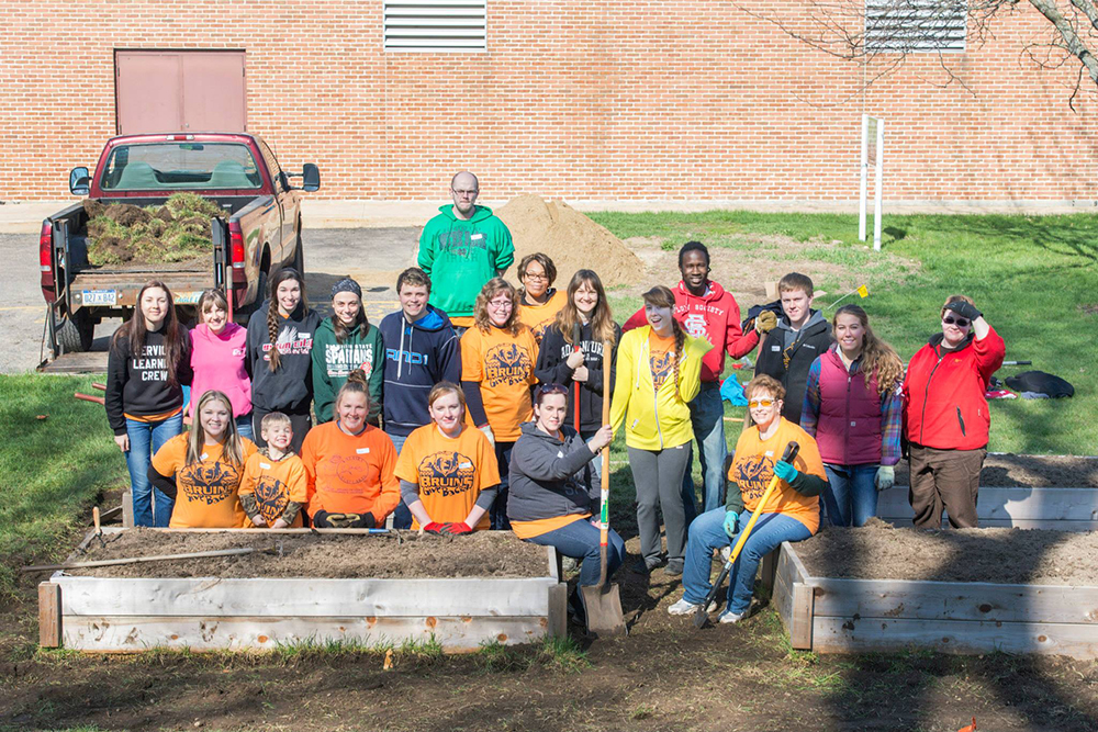 Volunteers pose for a group photo while working in KCC's community garden during a Bruins Give Back volunteer event.