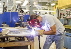 A KCC employee welds at the RMTC campus in Battle Creek.