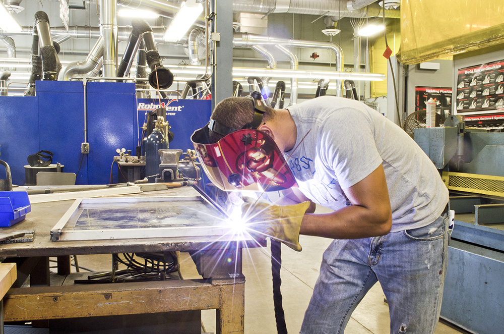 A KCC employee welds at the RMTC campus in Battle Creek.