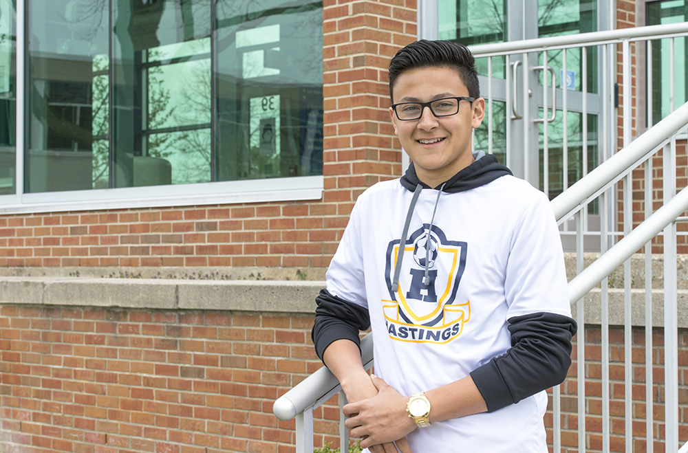 Dual-enrolled KCC student Andres Carmona poses outside the main entrance on KCC's North Avenue campus in Battle Creek.