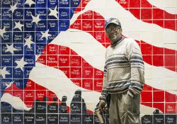 KCC alumnus Ron Leigh stands in front of an American flag mosaic at Silver Star Apartments in Battle Creek. Each tile includes the name of a resident at the facility, which houses homeless veterans.