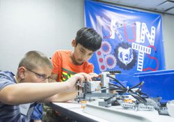 Youth Bruin Bots participants work on a robot during a robotics camp at the RMTC campus in Battle Creek.