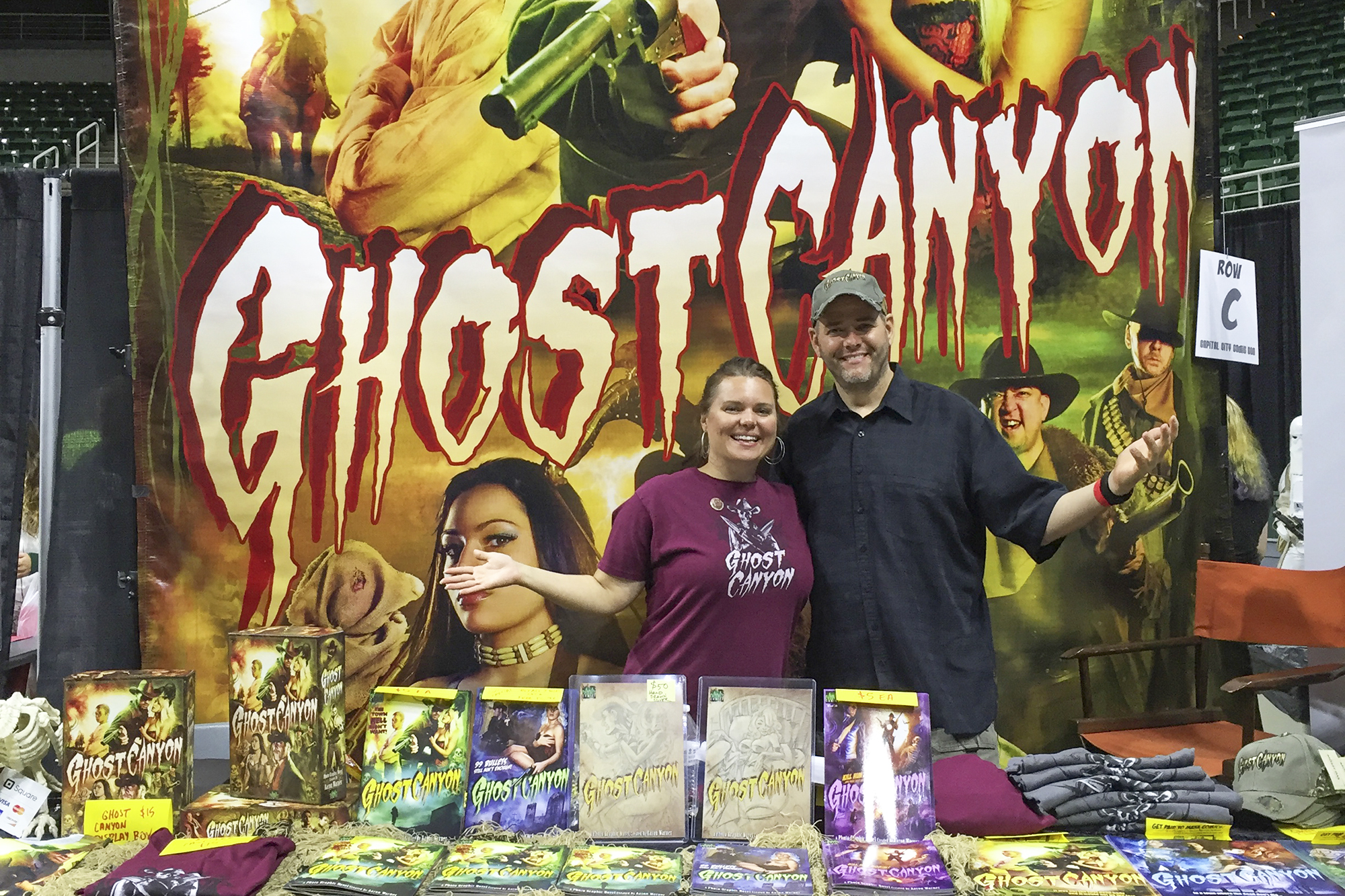 KCC alum and comic creators Angie and Aaron Warner stand at a comic book display featuring their newest title, Ghost Canyon.