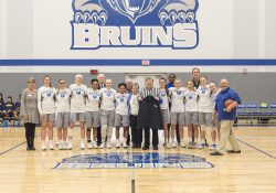 Former Battle Creek mayor Al Bobrofsky, who officiated the College's first basketball game in 1966, poses with wife Ann, the KCC women's basketball team and college officials before the start of the women's basketball game on Dec. 5, 2018.