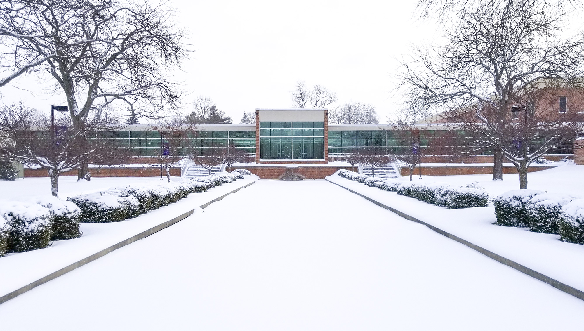 An exterior view of the main entrance to KCC's North Avenue campus in Battle Creek, covered in snow.