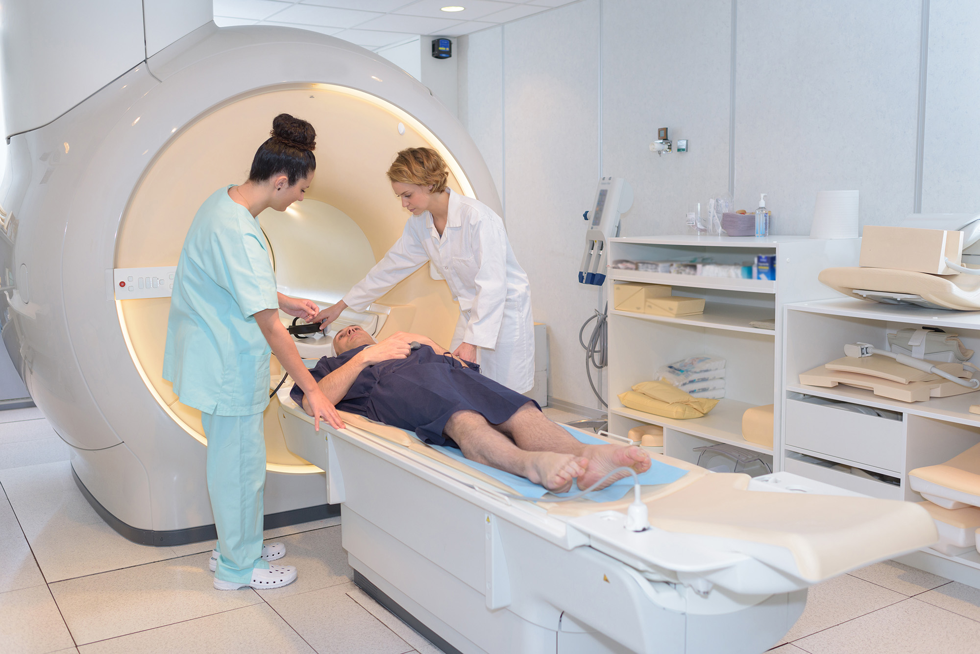 Health care workers prepare a patient for an MRI.