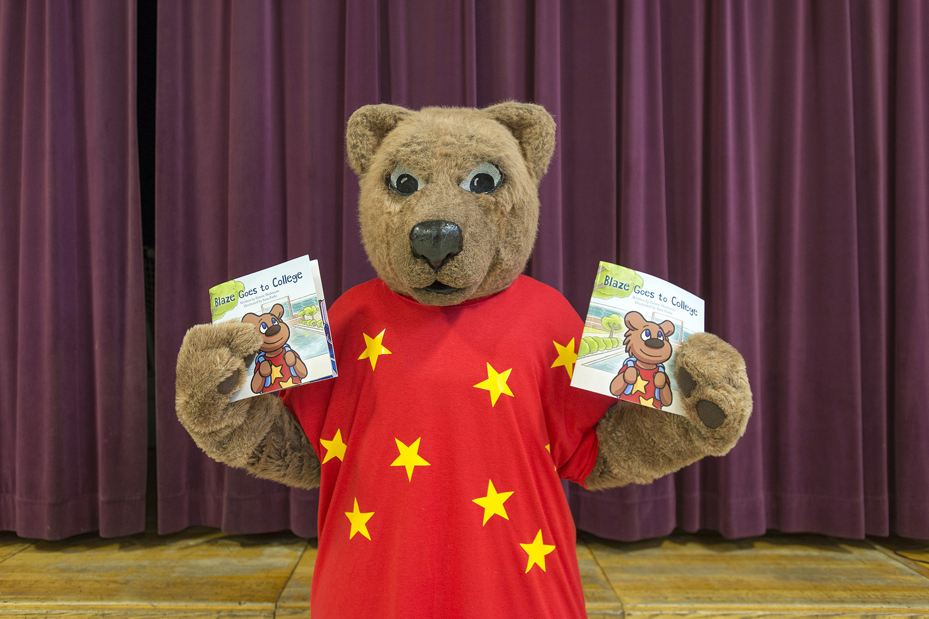 KCC mascot Blaze holds copies of the College's new children's book "Blaze Goes to College."