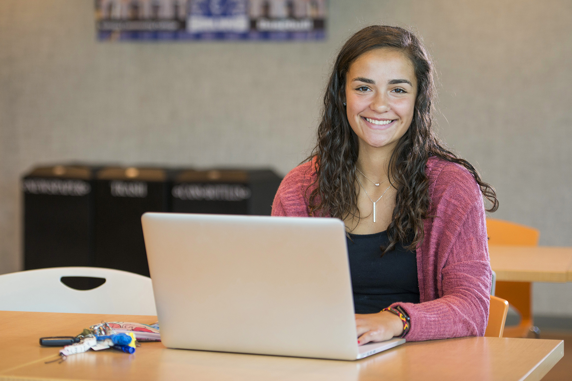 A student poses with a laptop in the Student Center.