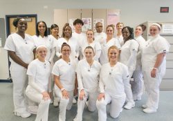 A group photo of CNA Program graduates posing in the CNA Lab.