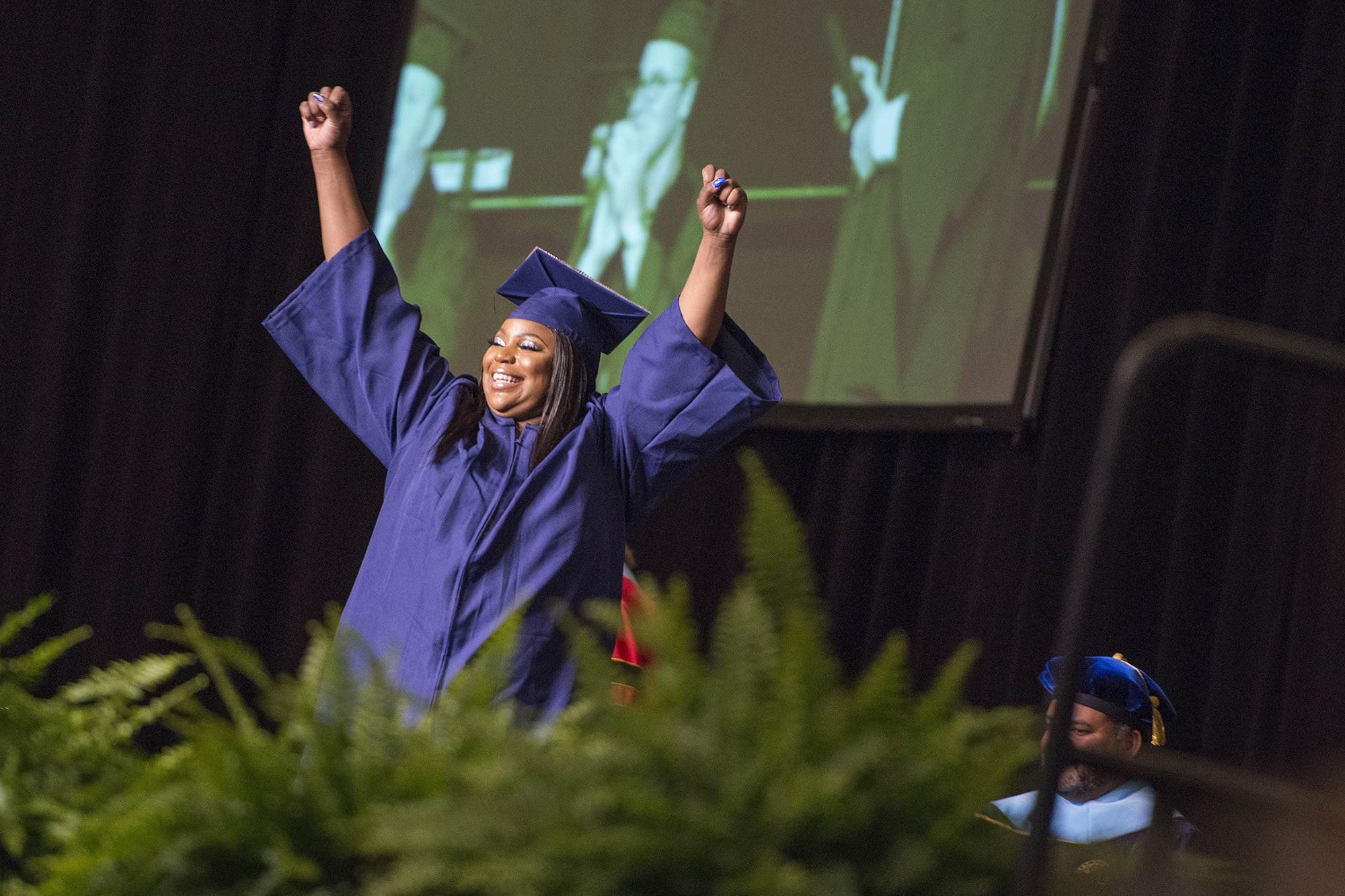 A graduate celebrates onstage during KCC's 2019 commencement ceremony.