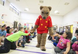 KCC mascot Blaze gives kids high-fives during a reading event at a local elementary school.