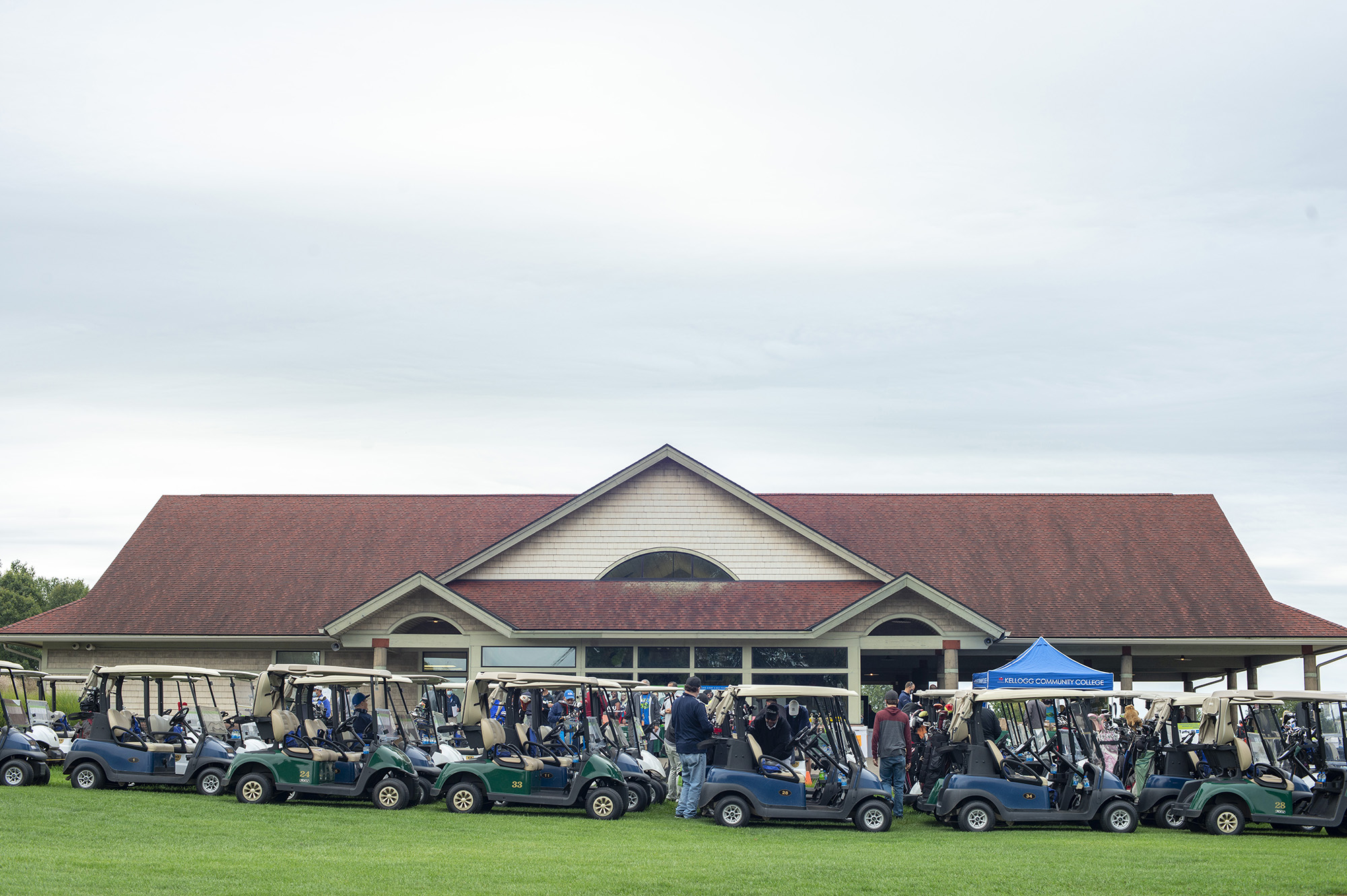 Golf carts and golfers lined up in front of the clubhouse at Binder Park Golf Course.