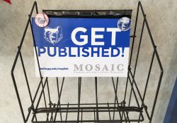 An empty rack with a sign on it that reads "Get published! Mosaic."