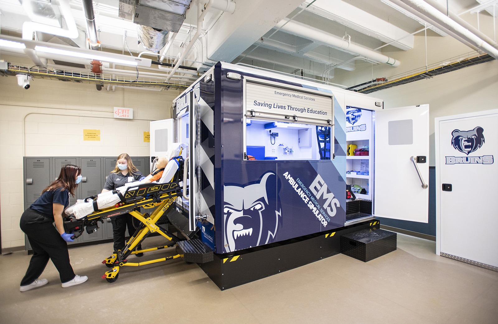 Students practice taking a patient from an ambulance in the EMS Sim Lab.