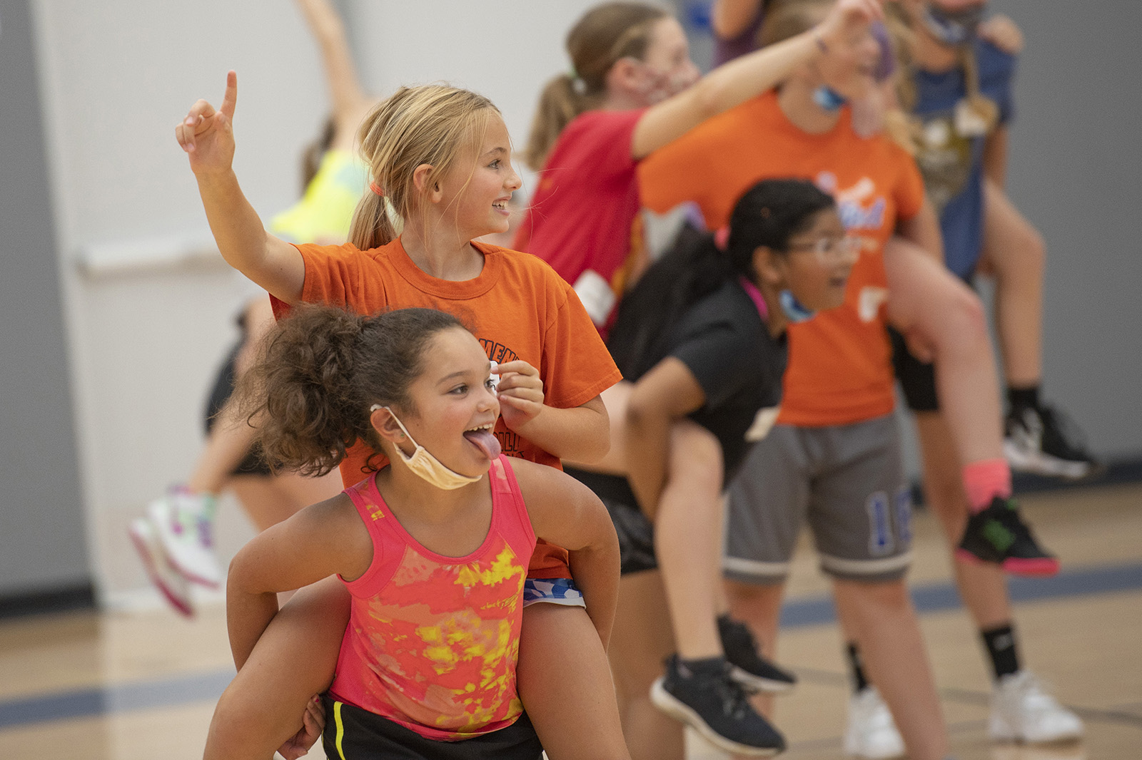 Girls play in the gym during a youth basketball camp.