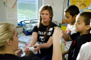 KCC softball players work with kids at a local elementary school during a recent Bruins Give Back volunteer event.