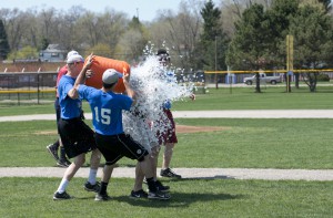 Members of the baseball team soak head coach Eric Laskovy at Wednesday's practice in celebration of their championship title.
