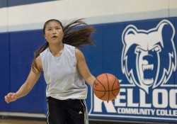 A basketball camp participant dribbles a basketball in the Miller Gym.