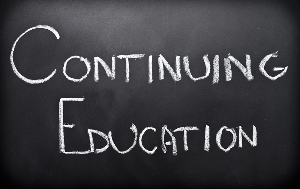 The words "continuing education" writing in chalk on a blackboard