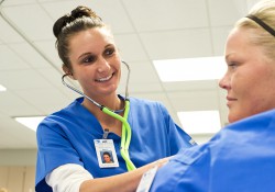 A KCC Nursing student works on another student during class