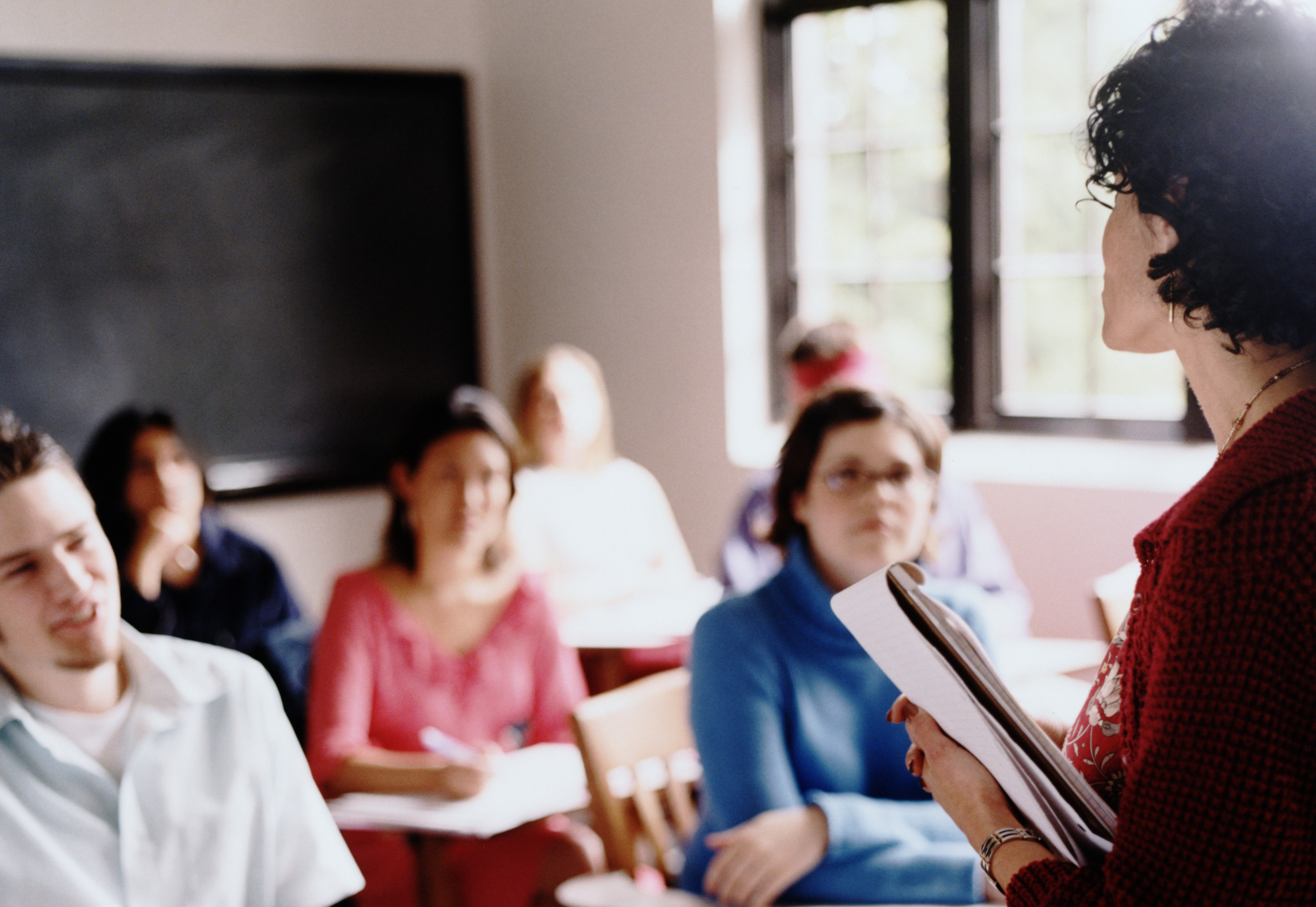 A stock photo of students listening to an instructor in class.