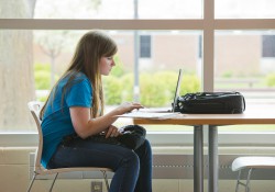 Female student using a laptop in the Student Center.