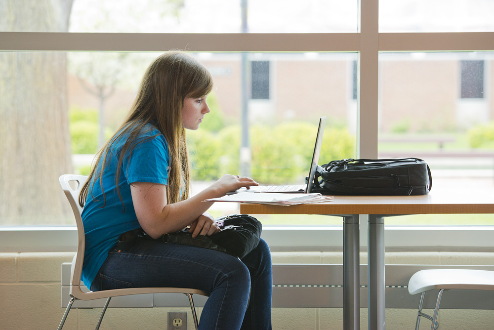 Female student using a laptop in the Student Center.