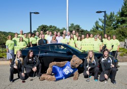 KCC Foundation Bruin Scholarship Open volunteers pose for a group photo with a car in front of the North Avenue campus.