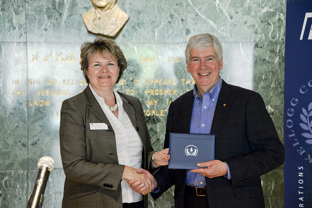 Vice President of Student and Community Services Kay Keck presents Michigan Gov. Rick Snyder with a degree.