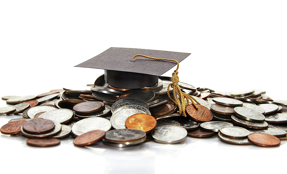 A stock image featuring a graduation cap on a pile of coins.