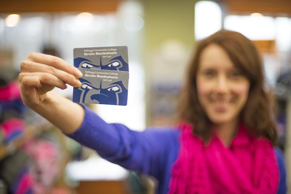 A Bruin Bookstore employee holds up two bookstore gift cards.