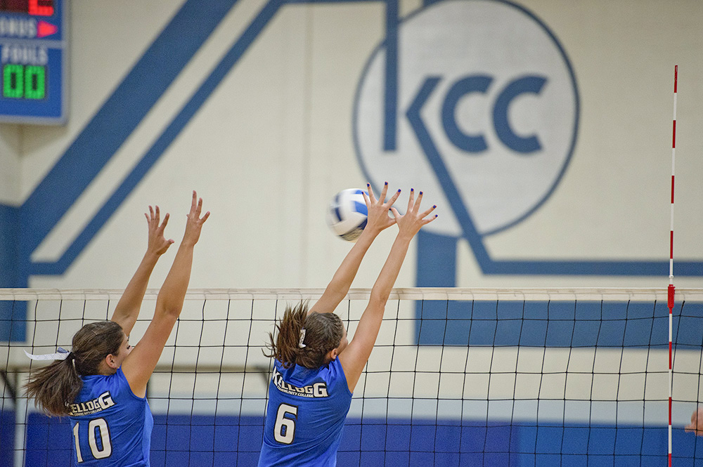 KCC women's volleyball players block the ball during a home game at the Miller Gym.