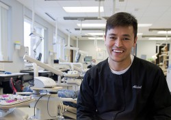 A male dental hygiene student poses in the KCC Dental Hygiene Clinic