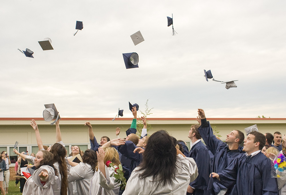 Calhoun Community High School graduates throw their caps in the air to celebrate following their commencement ceremony in 2013. Photo by Nick Garrison.