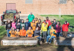 Volunteers pose for a group photo while working in KCC's community garden during a Bruins Give Back volunteer event.