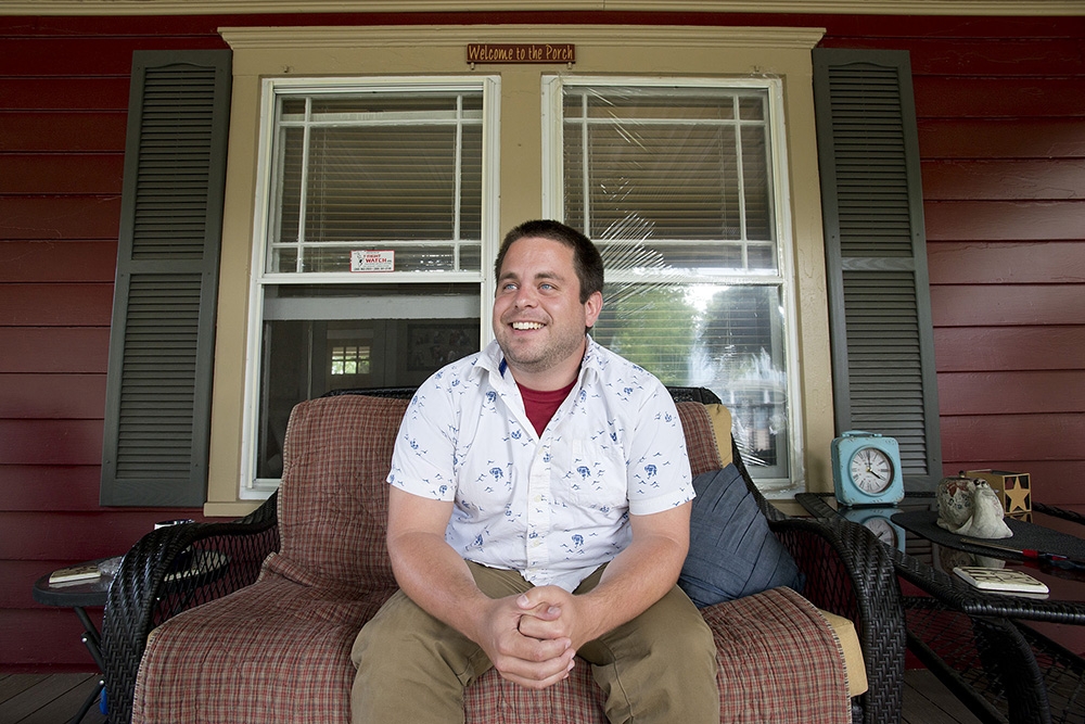 KCC alumnus Jordan Blekking sitting on a porch