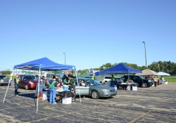 Health officials assist patients in their cars in a KCC parking lot during a drive-through flu-shot event.