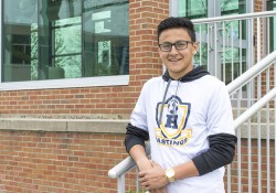 Dual-enrolled KCC student Andres Carmona poses outside the main entrance on KCC's North Avenue campus in Battle Creek.
