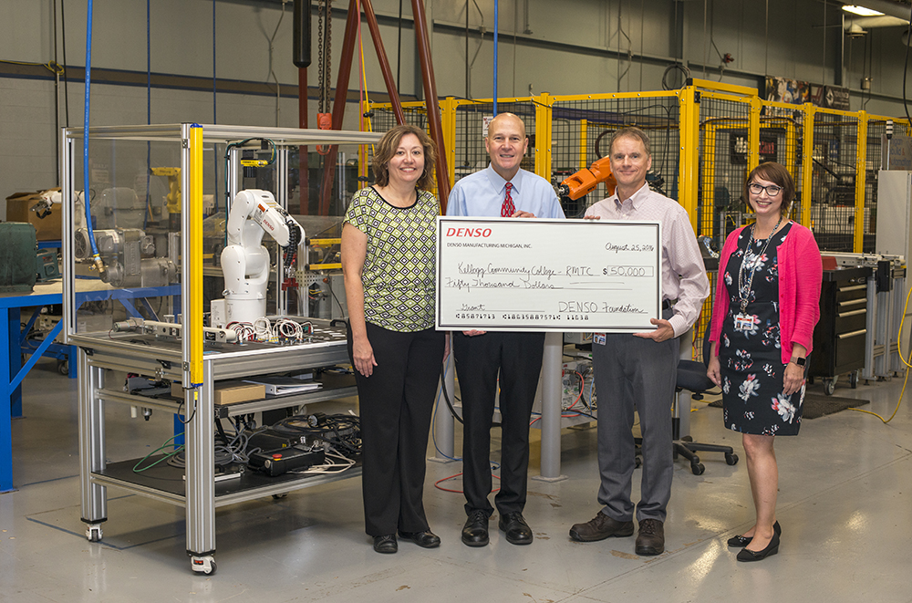 RMTC Director Tom Longman, second from the left, accepts grant funds from DENSO representatives at the RMTC in August.