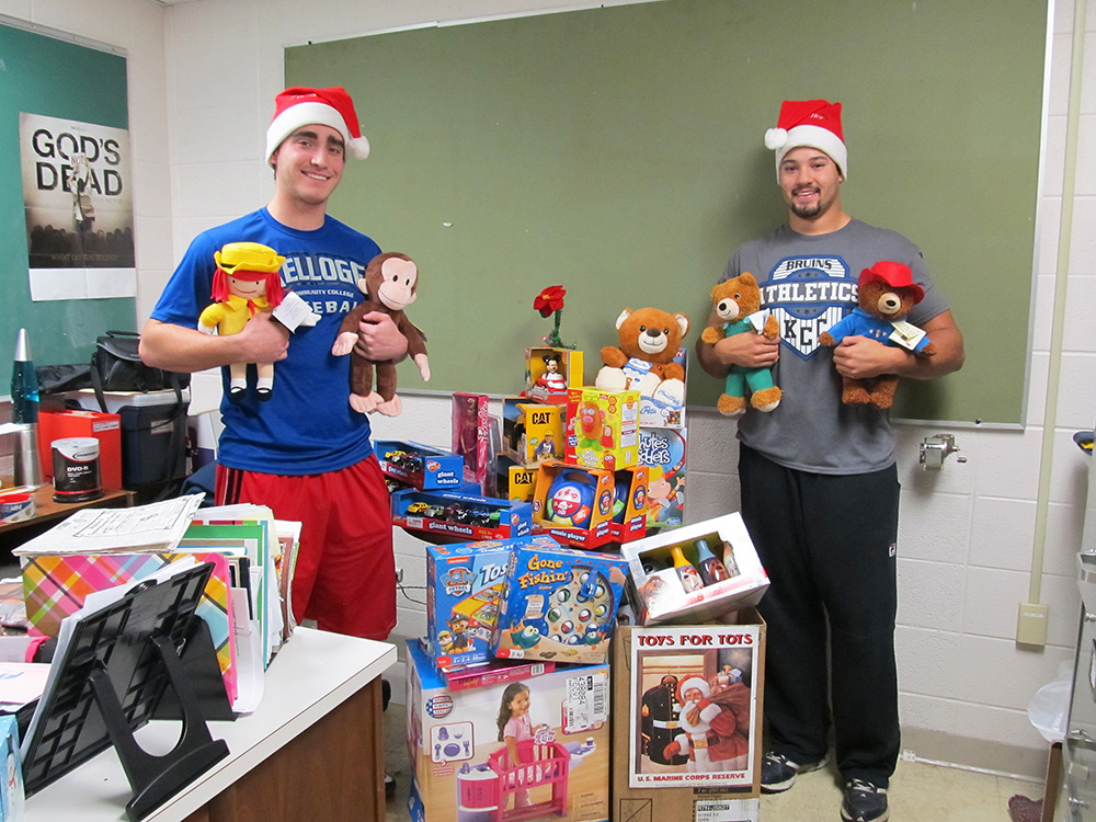 KCC baseball players (left to right) Bailey Peterson and Alex Walton, posing with donated Toys for Tots toys before they were picked up for distribution.