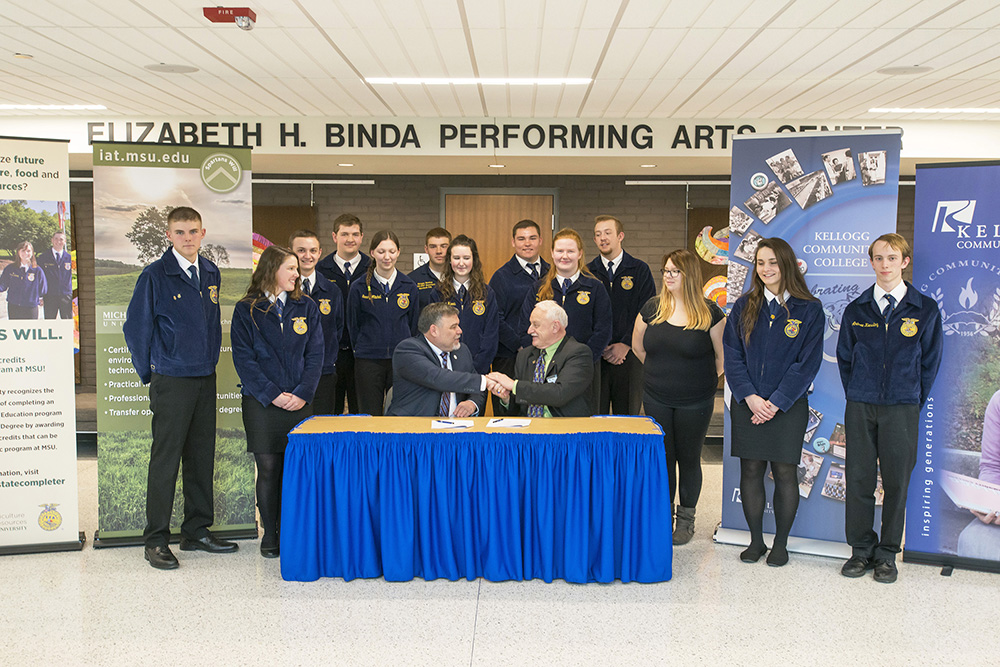 MSU IAT Director Dr. Randy Showerman, left, shakes hands with KCC President Mark O'Connell as FFA students look on after the two officials signed an inter-institutional understanding agreement formalizing the ag program partnership at KCC on March 6.