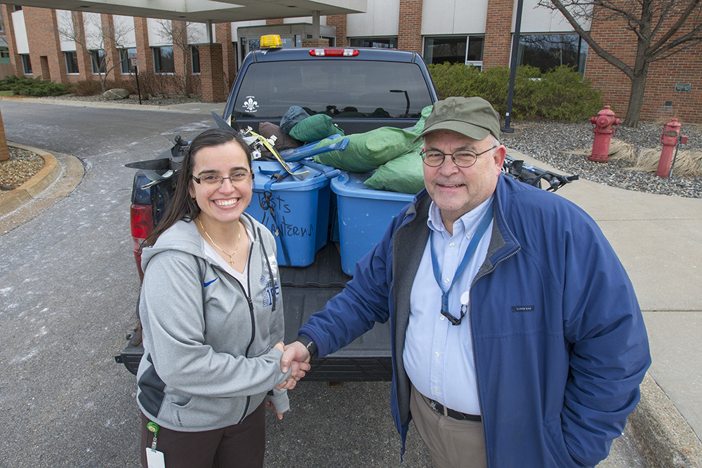KCC Foundation Scholarship Technician Jackie Hallahan, left, shakes hands with area Boy Scouts of America troop leader Kevin Linders as Linders picks up a KCC Foundation donation on campus in Battle Creek.